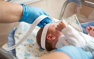 Położna mierząca noworodka na oddziale położniczym w szpitalu Salve