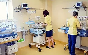 Położna badająca noworodka na oddziale neonatologicznym w szpitalu Salve