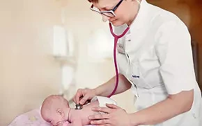 Położna badająca noworodka na oddziale neonatologicznym w szpitalu Salve